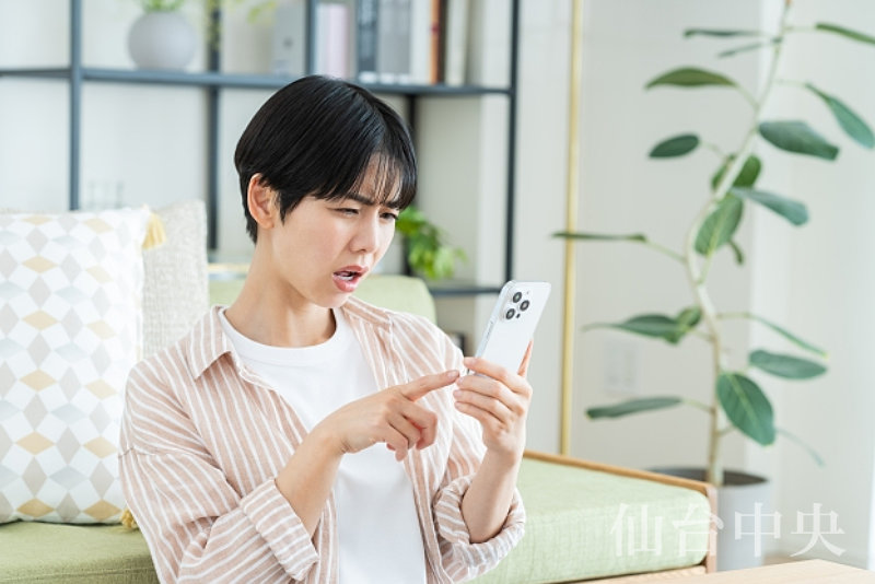 埋没法後のゴロゴロ感に対する治療をスマホで検索する女性